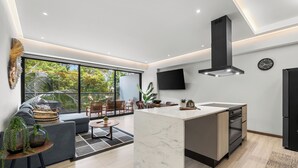 Cocina moderna con isla central, horno empotrado y un amplio ventanal con vistas a zonas verdes.