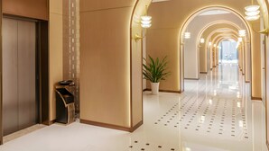 A modern hotel lobby with a long corridor, arched lighting, and a potted plant. - Magnotel Guilin Elephant Trunk Hill (Guilin)
