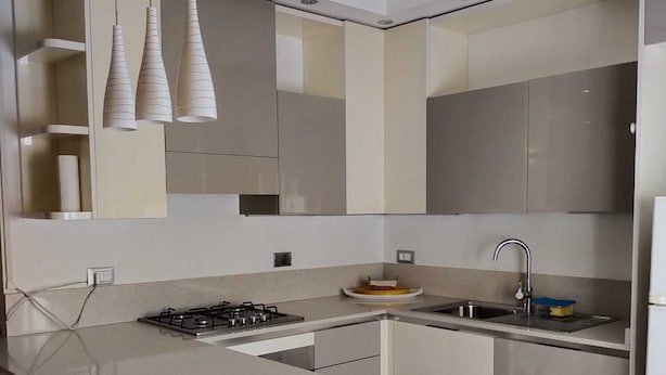 A modern kitchen with a central island, stainless steel appliances, and pendant lighting.