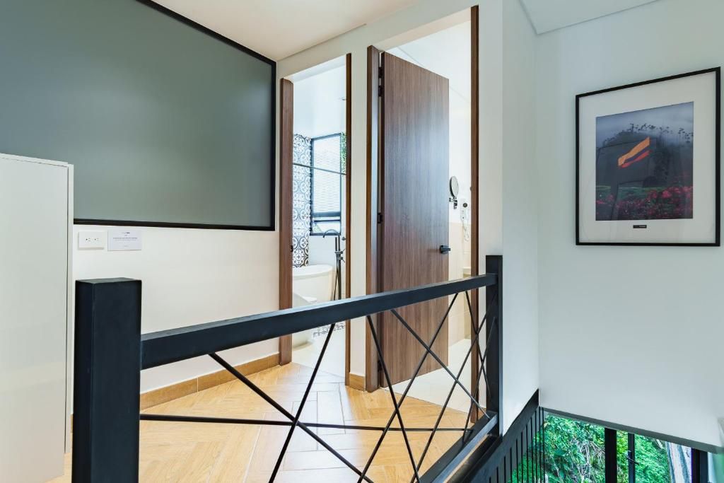A modern interior with a staircase, wooden doors, and a framed picture on the wall.