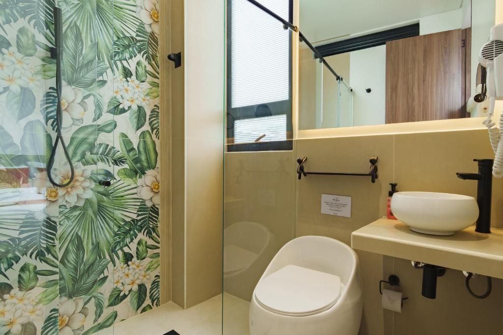 A bathroom with a toilet, a sink, and a shower area.