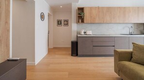 A modern kitchen with wooden cabinets, a marble countertop, and a built-in sink.