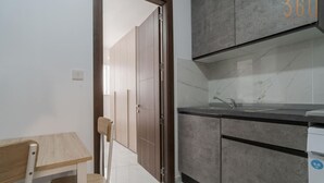 Eine moderne Küche mit grauen Schränken, einer Marmorarbeitsplatte und einem Spülbecken.