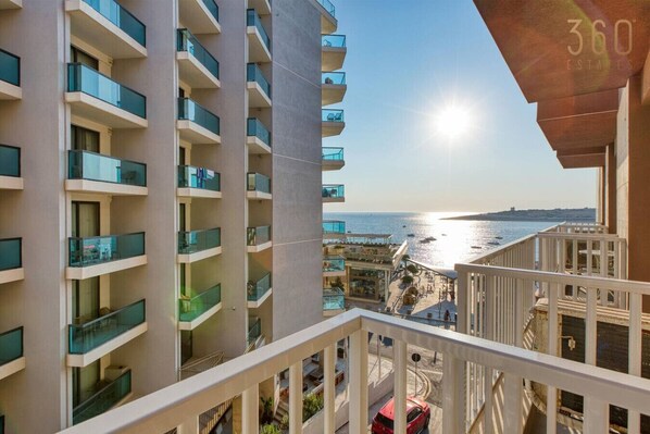 Un edificio alto con varios balcones que dan a la costa.