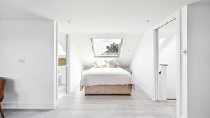 A bedroom with a skylight, a bed, and a view of the outdoors.
