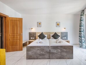 A modern bedroom with a large bed, two nightstands, a wooden door, and a window with curtains.