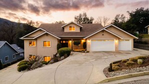 A two-story house with a garage, a driveway, and a landscaped front yard.