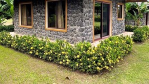 Una casa de piedra con techo inclinado, ventanas grandes y un pequeño porche.