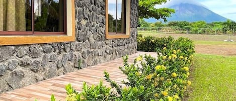 A stone building with a wooden deck and a view of a mountain.