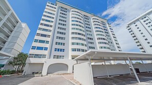A modern multi-story building with a curved facade, large windows, and a flat roof.