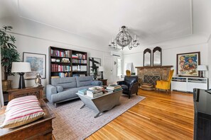 A living room with a sofa, coffee table, bookshelf, and a fireplace.