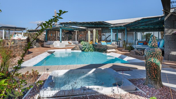 A pool area with a hot tub, lounge chairs, and a decorative cactus sculpture. - Holiday Villa 'Dafmir' with Sea Views, Wi-Fi and Air Conditioning (Tías)