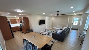 Un apartamento moderno con comedor, cocina, sala de estar y un balcón.