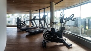Une salle de sport équipée de matériel d’exercice, dotée de grandes fenêtres et d’un plafond en bois.