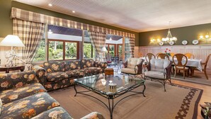 A spacious living area with a sofa set, a glass coffee table, and a dining area with chairs and a table. - Granja Comary House with private pool and jacuzzi (Teresópolis)