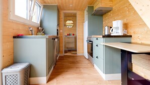 Una cocina estrecha con paredes de madera y una isla central, un fregadero y una estufa.