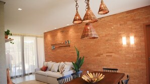 Una sala de estar moderna con pared de ladrillo, una mesa de comedor de madera y un sofá.