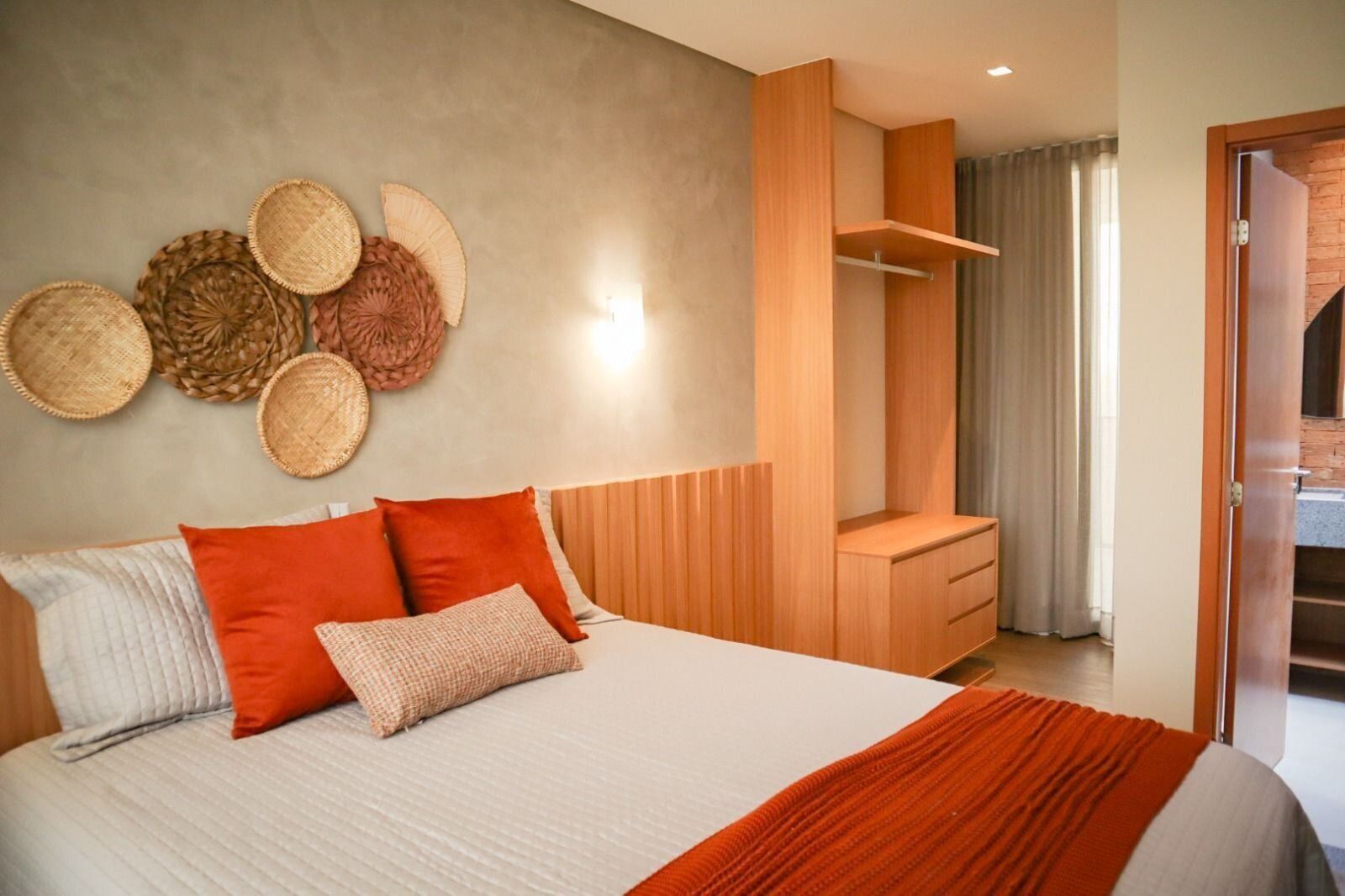 Une chambre moderne avec un grand lit, une armoire en bois et un mur décoré de paniers tressés.