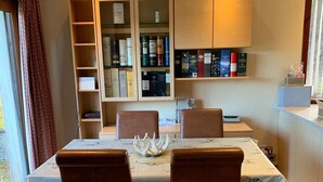 A dining area with a table set for four, surrounded by bookshelves filled with books and decorative items.