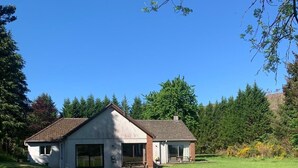 A two-story house with a large front lawn and a garage.