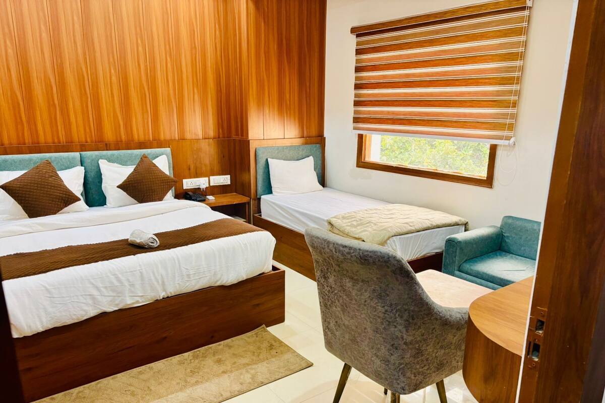 Un dormitorio moderno con una cama grande, una cama más pequeña, un escritorio y una silla.