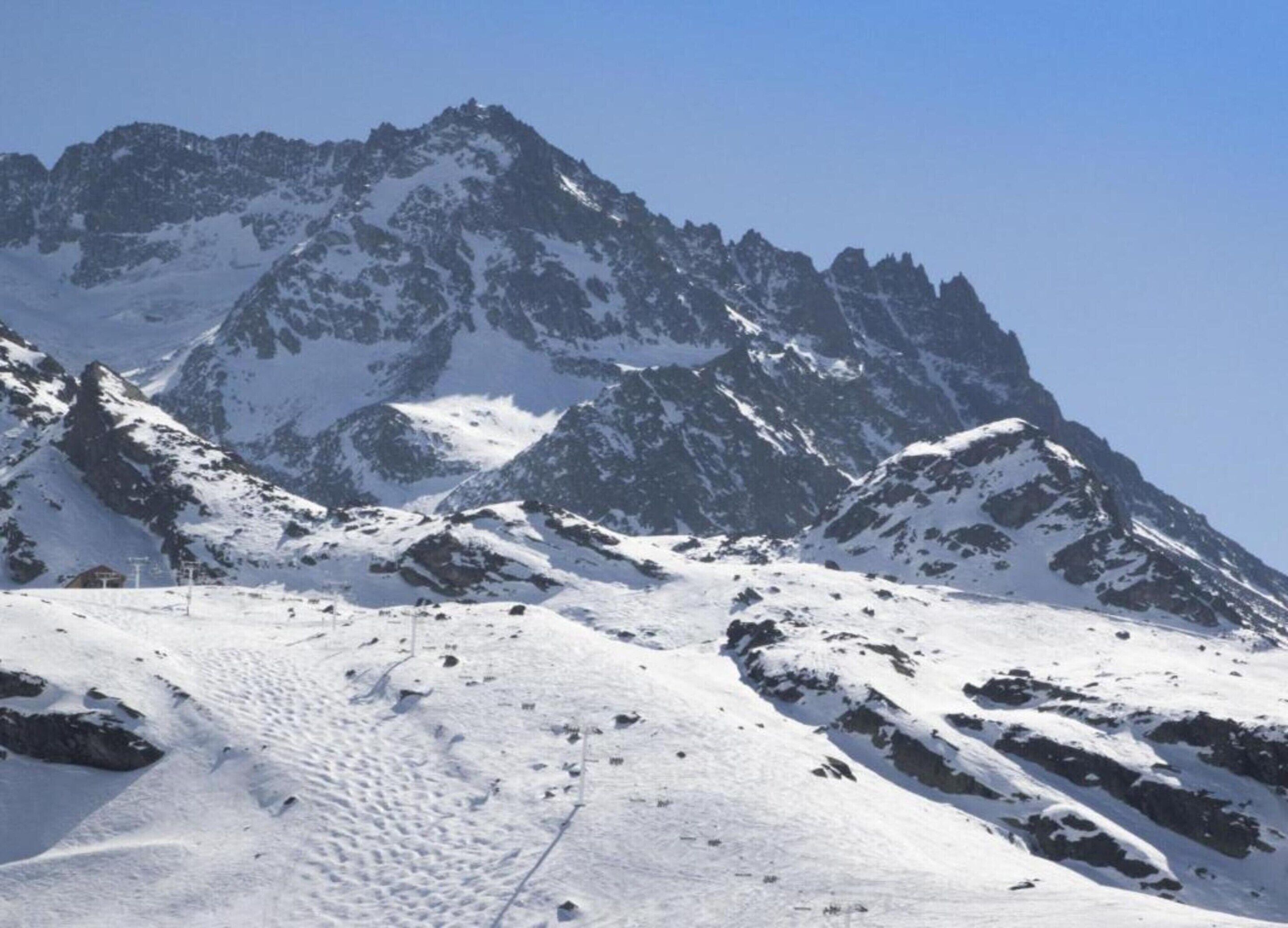 Ein mit Schnee bedeckter Berg unter klarem Himmel.