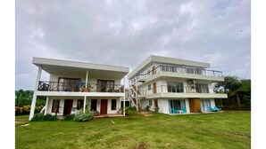 A two-story building with a flat roof, large windows, and a balcony on the upper floor. - Savannah House (San Andrés y Providencia)