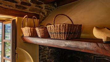 Wicker baskets on a wooden shelf, a stone wall, and a door leading outside.