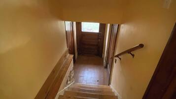 A wooden staircase leading to a second floor with a small window at the top.