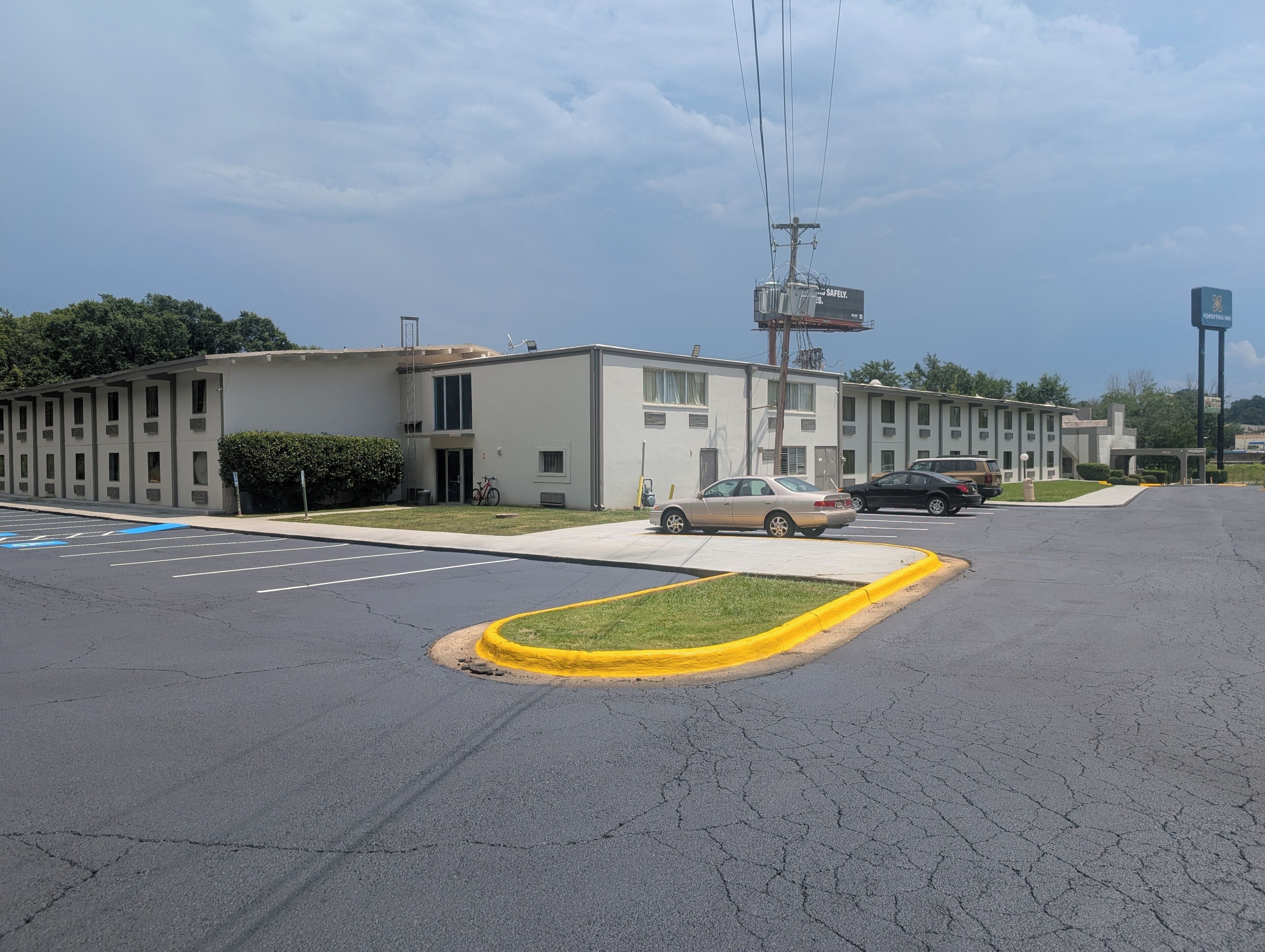 A parking lot with a building featuring multiple windows and a visible entrance.