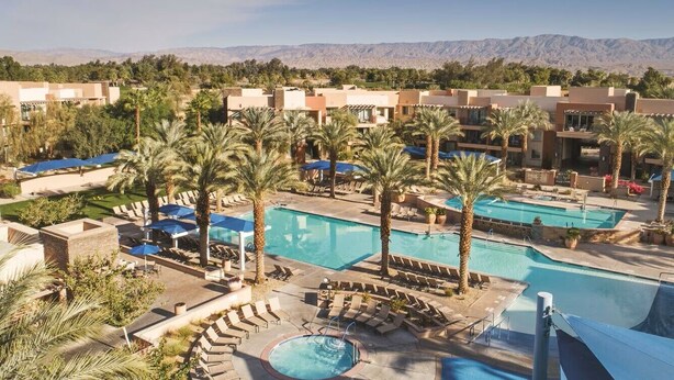 A resort with multiple swimming pools, palm trees, and a mountainous backdrop. - Marriott Shadow Ridge The Enclaves COACHELLA STAGECOACH (Palm Desert)