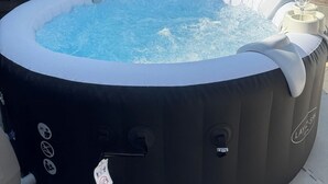 A black inflatable hot tub with a control panel, a glass, and a tag. - Stylish 3-Bed • Hot Tub • Free Parking • Contractors (Essex)