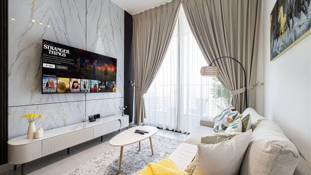 Una sala de estar moderna con pared de mármol, un televisor de pantalla plana, un sofá y una mesa de centro.