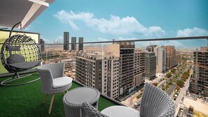 Un balcón con vistas a un paisaje urbano, que incluye edificios altos y zonas de construcción.