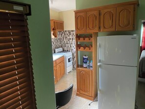A kitchen with wooden cabinets, a white refrigerator, and a stove.