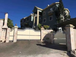 A large, multi-story building with a gated entrance, likely a hotel or residential complex.