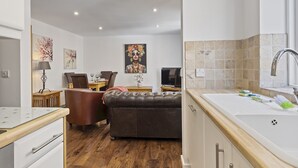 Una cocina moderna con comedor, sofá y televisor.