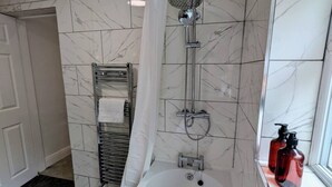 A bathroom with a shower, a bathtub, a towel rack, and a window. - Contractors 4BR Home, Newly Refurb, Nr Centre (West Midlands)