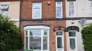 A two-story residential building with a bay window on the ground floor, a white door with the number 55, and a satellite dish on the upper floor. - Contractors 4BR Home, Newly Refurb, Nr Centre (West Midlands)