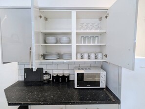 A compact kitchen with white cabinets, a microwave, and a coffee maker. - Contractors 4BR Home, Newly Refurb, Nr Centre (West Midlands)