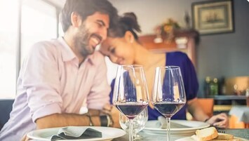 Una mesa de comedor con dos copas de vino y un plato de pan.