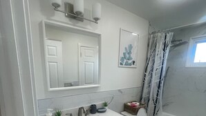 A bathroom with a white sink, vanity, and toilet. There is a shower curtain with a tree pattern, a small plant on the vanity, and a framed picture on the wall. - Spacious 3-Bedroom Home Awaits 2nd Floor - Designed for Comfort & Relaxation!!! (New Britain)