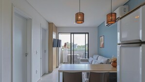 A modern kitchen with a dining table, chairs, and a large refrigerator. - Edifício Tours Du Porto (Ipojuca)