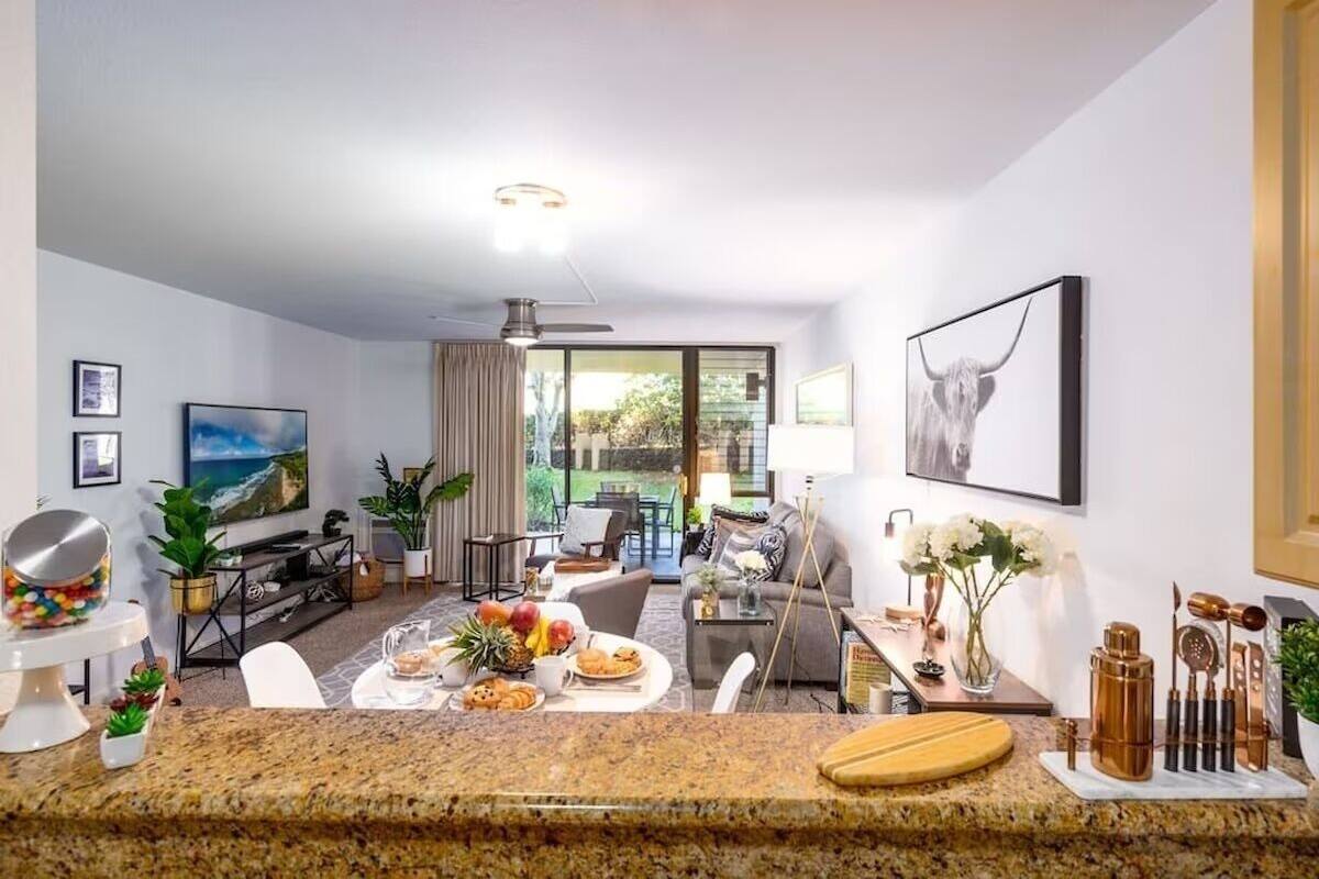 Ein modernes Wohnzimmer mit Essbereich, Fernseher und großem Fenster.