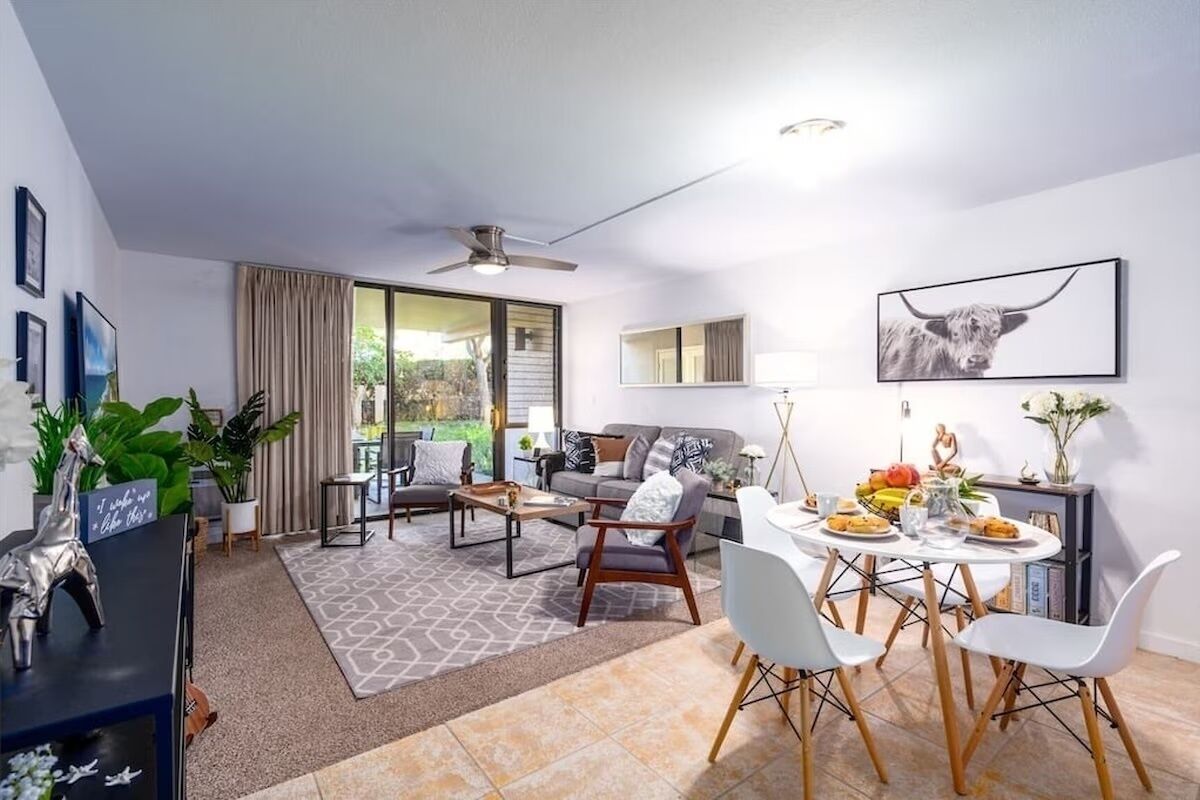 A modern living room with a sofa, coffee table, and dining table set for a meal.