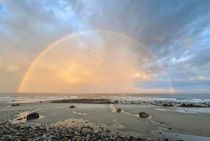 A beach with a rainbow, rocks, and a cloudy sky. - "Leaf Peeping" Season, Fall Colors, Fairs & Family (Wells)