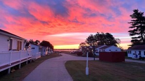 A pathway leading to mobile homes with a sunset in the background.