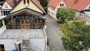 Ein Gebäude mit geneigtem Dach, einer Holzfassade und einer Steintreppe, die zu einer oberen Ebene führt.