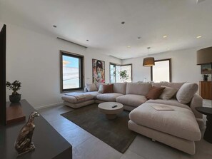 A modern living room with a sectional sofa, a round coffee table, and a dog statue. - Sky villa penthouse, private pool | MIL by Homega (St. Julian's)