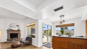 A modern kitchen with wooden cabinets, a built-in oven, and a large window. - Dive In Desert - 3Bd - Pool Oasis (Chandler)